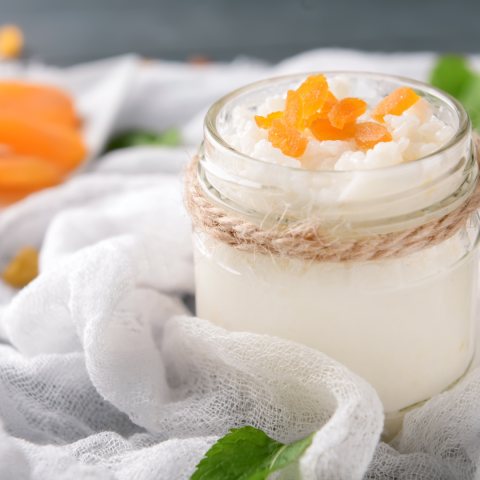 Rice pudding in a glass jar, topped with pieces of dried apricot